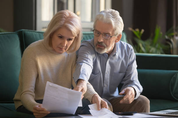 istock Serious grey haired mature couple calculating bills, checking finances together 1147376427