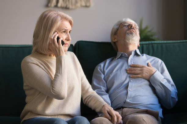 istock Mature woman calling emergency, grey haired man having heart attack 1147376429