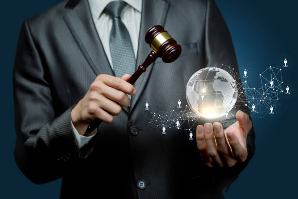 istock An auctioneer holding a hammer and a globe. 1147379694