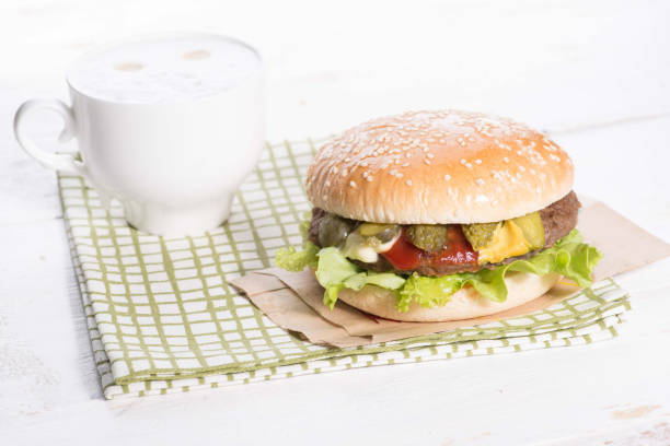 istock cup of coffee and burger on a served white table 1147380505