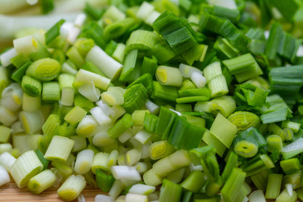 istock Raw green garlic on cutting board preparated for cooking. 1147381215