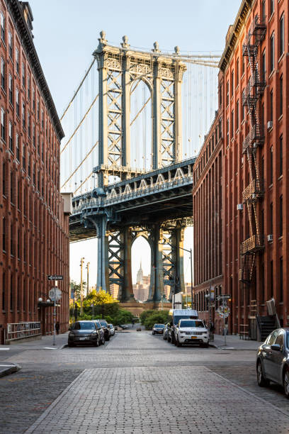 Brooklyn, NY DUMBO neighborhood street scene with Manhattan Bridge and Empire State Builiding Brooklyn, NY DUMBO neighborhood street scene with Manhattan Bridge and Empire State Builiding borough district type photos stock pictures, royalty-free photos & images