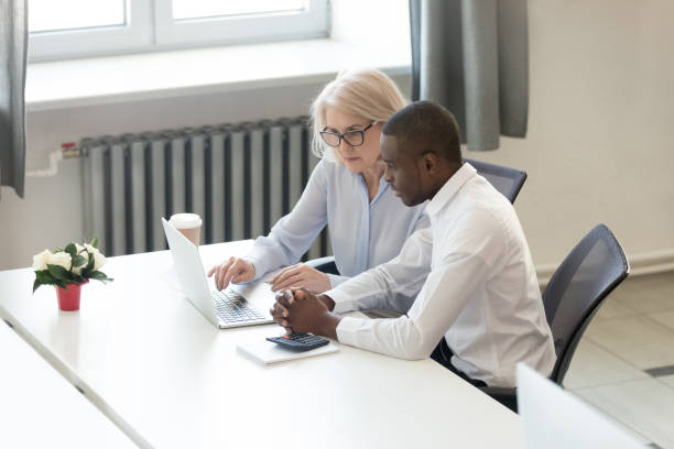 istock Concentrated diverse employees sitting at desk working using laptop 1147384763