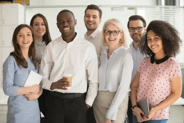 Photo of Positive multi racial corporate team posing looking at camera