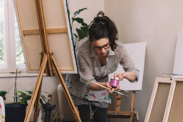 istock Young female artist painting in her studio 1147387569