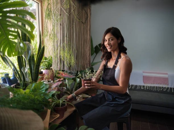 istock Friendly store employee working on fixing plants for a garden shop 1147393222