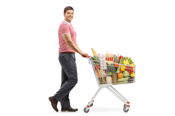 istock Young man with a shopping cart smiling at the camera 1147393344