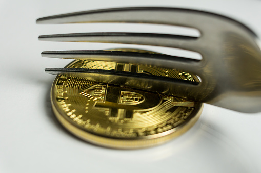 Macro photo of Bitcoin cryptocurreny fork concept with reflection, hard fork 12.1.2019 Ljubljana Slovenia