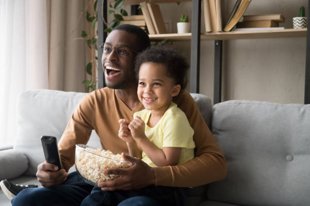 행복 한 아프리카계 미국인 아버지와 아들 tv 시청, 팝콘 먹기 - american football football food snack 뉴스 사진 이미지