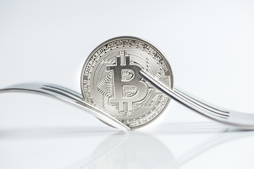 Macro photo of Bitcoin cryptocurreny fork concept with reflection, hard fork 12.1.2019 Ljubljana Slovenia