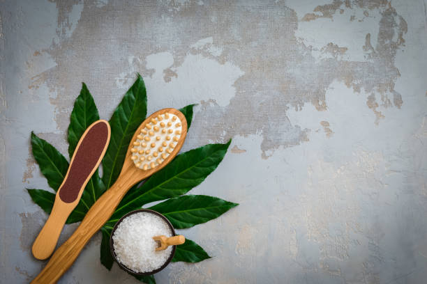 istock Body spa treatment bamboo brushes with bath salt on green tropical leaf background 1147397957