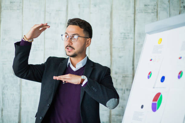 Young hipster businessman perform his ideas on white chalkboard