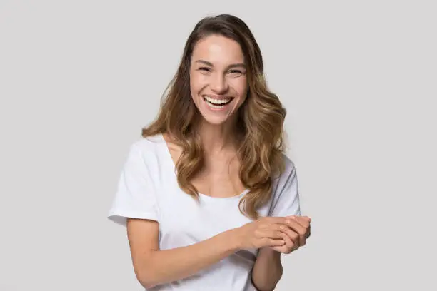 Photo of Woman looking at camera laughing feels happy studio shot