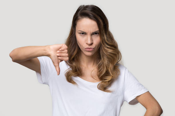 istock Angry woman showing thumb down disapproval gesture studio shot 1147400432