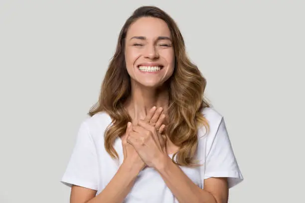 Photo of Excited woman feels happiness and gratitude come from heart concept
