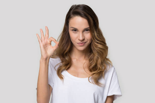 Attractive woman posing in studio showing ok sign