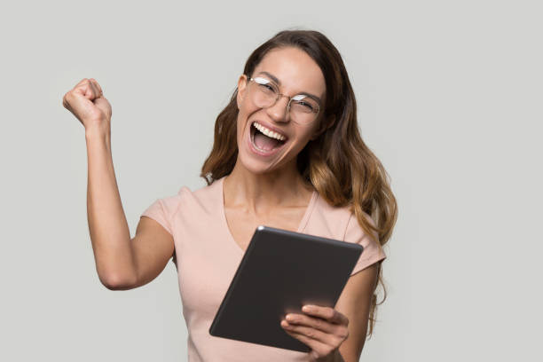 Happy woman in glasses holding digital tablet screaming celebrating win Happy woman in glasses holding digital tablet screaming with joy celebrating win received great news offers opportunities, make yes gesture, lucky success victory goal achievement, modern tech concept beautiful women giving head stock pictures, royalty-free photos & images