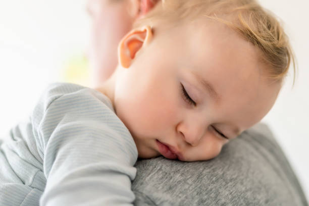 zbliżenie portret cute adorable blond kaukaski maluch chłopiec śpi na ramieniu ojców w pomieszczeniu. słodkie małe dziecko uczucie bezpieczeństwa daddys strony. odpowiedzialność i opieka nad dziećmi. szczęśliwe dzieciństwo - human hand reliability shoulder love zdjęcia i obrazy z banku zdjęć