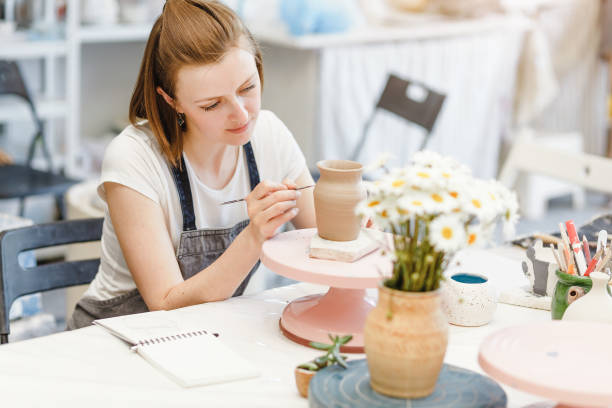 istock Workshop of clay pottery ceramic, woman decorating dishware pot 1147402064