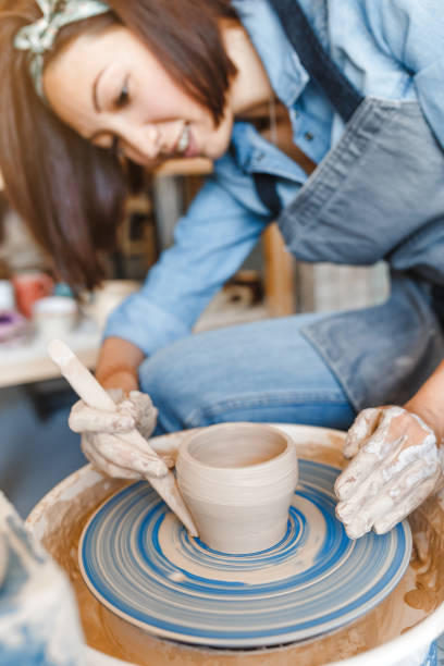 istock smiling woman making ceramic dishware on pottery wheel with clay, workshop and leisure concept 1147402070