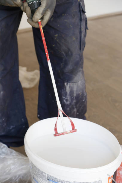 istock Man preparing white paint for interior walls 1147402954