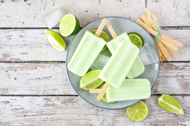 istock Lime yogurt popsicles, above view table scene against white wood 1147402986