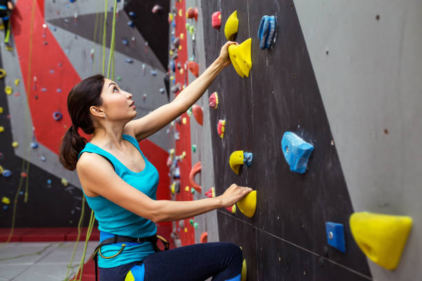 fit спортивная женщина смотрит на скалолазание стены в тренажерном зале и подготовки кадров - climbing rock climbing women determination стоковые фото и изображения