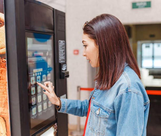 自動販売機からコーヒーを買う女性 - tea machine ストックフォトと画像