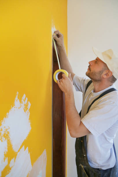 istock Man putting tape on the wall. The simple step for the quick and easy painting process. Renovation house concept. 1147403463