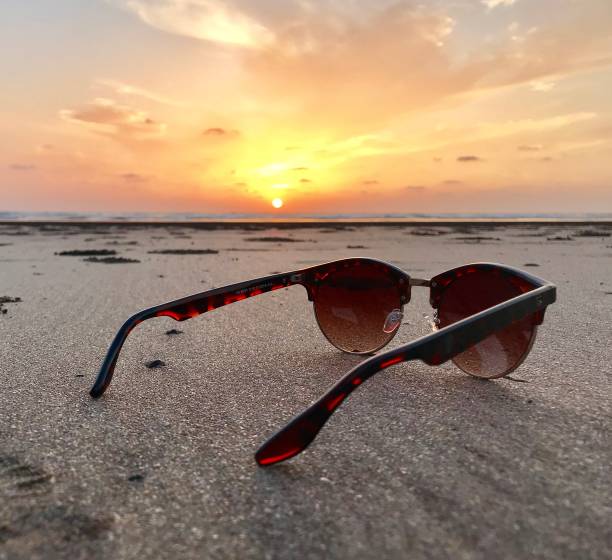 istock Sun glasses on beach during sunset 1147406638