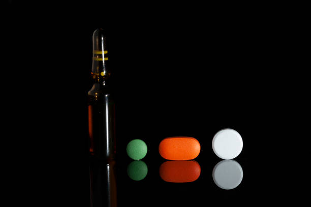 istock small medical bottles and various pills on the black background 1147407971
