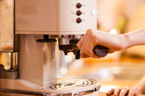 istock Woman in kitchen making coffee from machine 1147408843