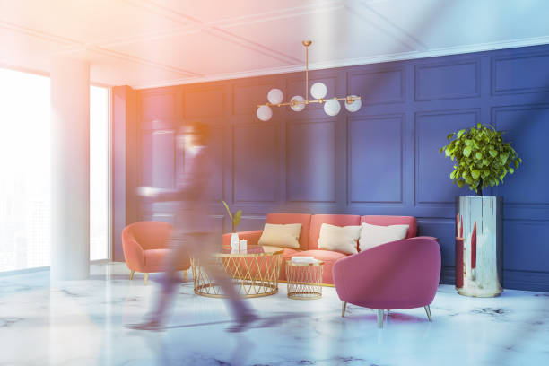 istock Man walking in blue living room with sofa 1147408962