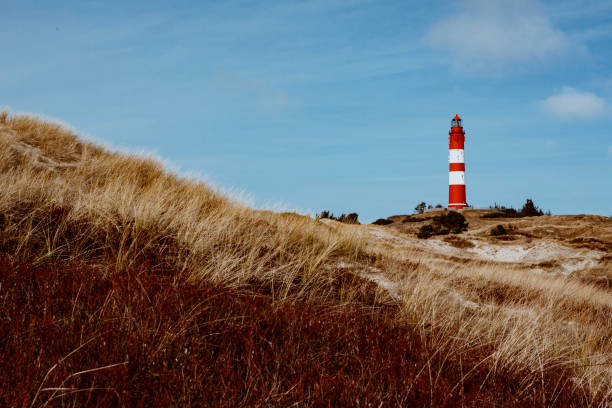 istock Red lighthouse on the hill in distance 1147409090