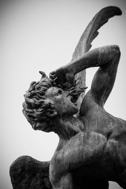 escultura del ángel caído en un día nublado en el parque el retiro madrid - demon statue ancient architecture fotografías e imágenes de stock