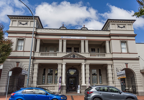 Facade of the former Australian Joint Stock Bank, completed in 1889 in Victorian architectural style with elegant columns and towers-like structures on the front corners, in Armidale, NSW, Australia