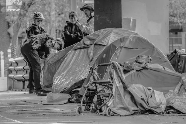 A black and white image of Portland, Oregon police looking inside a homeless person's tent.