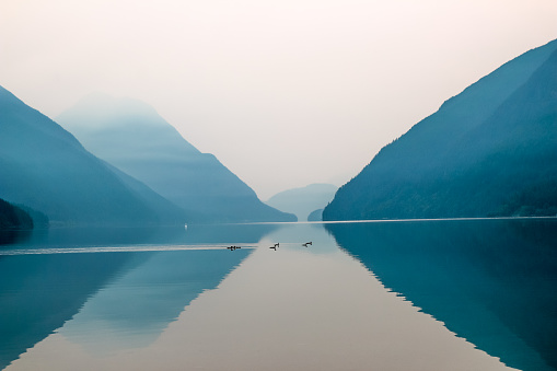 Refelection of mountains at a mystic foggy lake
