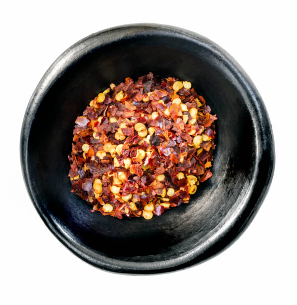 istock Hot Chilli Flakes in Black Bowl Isolated on White Top View 1147422993