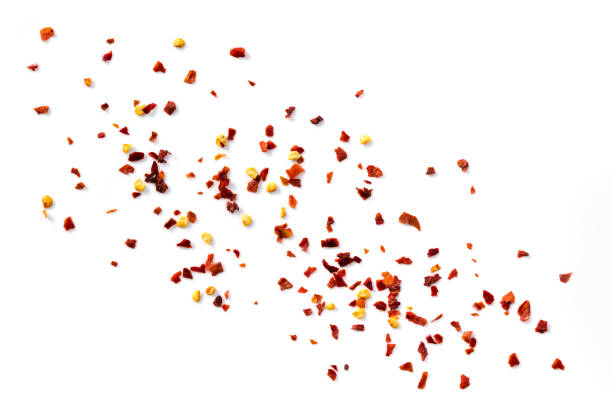 Chilli Flakes Scattered over White Background Top View Hot chilli flakes scattered over white background, top view. chili pepper photos stock pictures, royalty-free photos & images