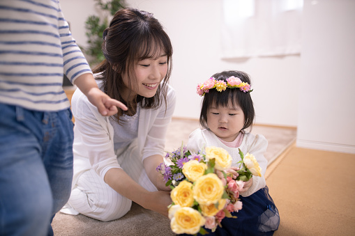 Mother giving bouquet to her baby girl for the first birthday