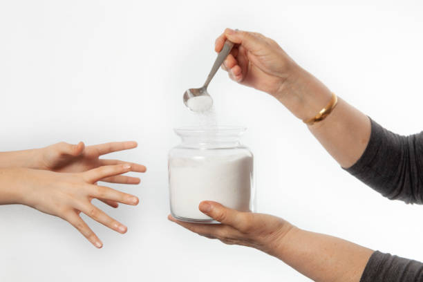 istock Isolated on white background, hand is holding candy in jar 1147424806