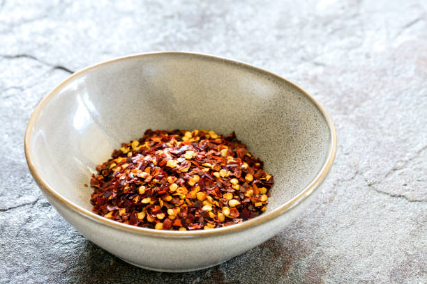 istock Hot Chilli Flakes in Stoneware Bowl over Slate Background 1147425744