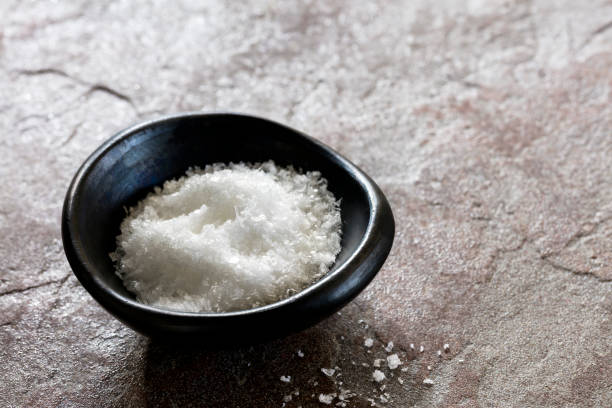 istock Sea Salt Flakes in Black Bowl over Slate 1147426823