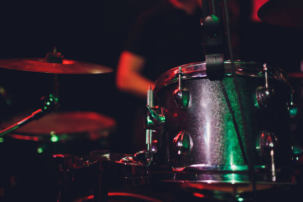 istock man plays musical percussion instrument with sticks closeup on a black background, a musical concept with the working drum, beautiful lighting on the stage. 1147429090