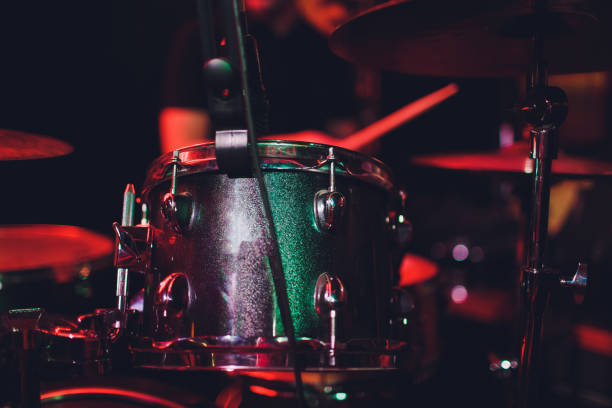 istock man plays musical percussion instrument with sticks closeup on a black background, a musical concept with the working drum, beautiful lighting on the stage. 1147429092