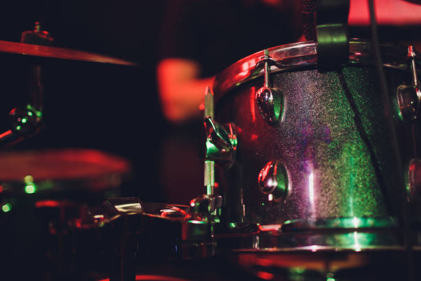 istock man plays musical percussion instrument with sticks closeup on a black background, a musical concept with the working drum, beautiful lighting on the stage. 1147429096