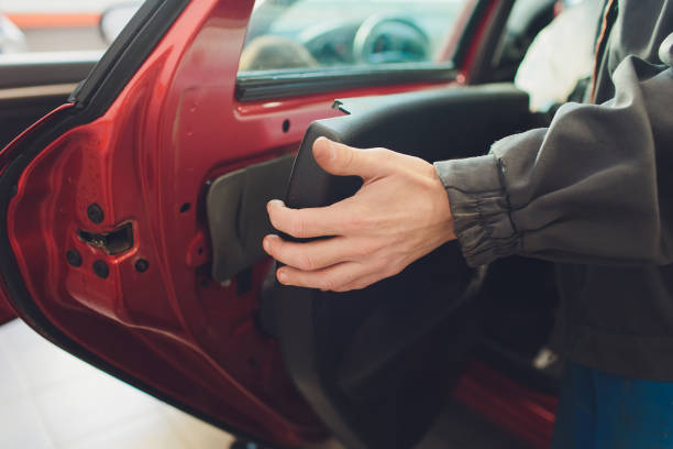 istock Mechanic installing car central door lock motor. 1147429152