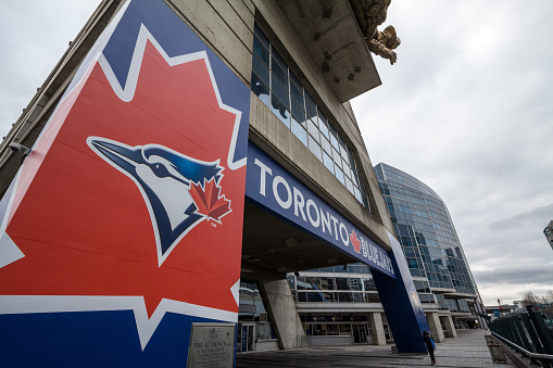 Picture of a sign with the logo of Toronto Blue Jays at the entrance of Rogers Center. The Toronto Blue Jays are a Canadian professional baseball team based in Toronto, Ontario competing in Major League Baseball as a member club of the American League East division