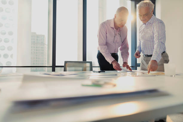 architecte d’hommes discutant des dispositions sur la table dans le studio de bureau - business meeting business pencil office worker photos et images de collection